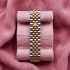 Rear view of two-tone steel-and-gold-tone Jubilee bracelet and crown clasp on pink cushion