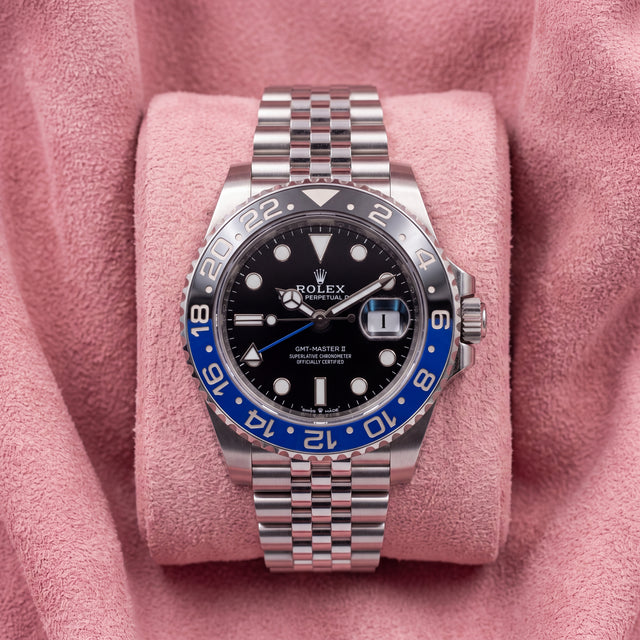 Front view of black-dial GMT-Master II with blue-and-black bezel and Jubilee bracelet on pink cushion