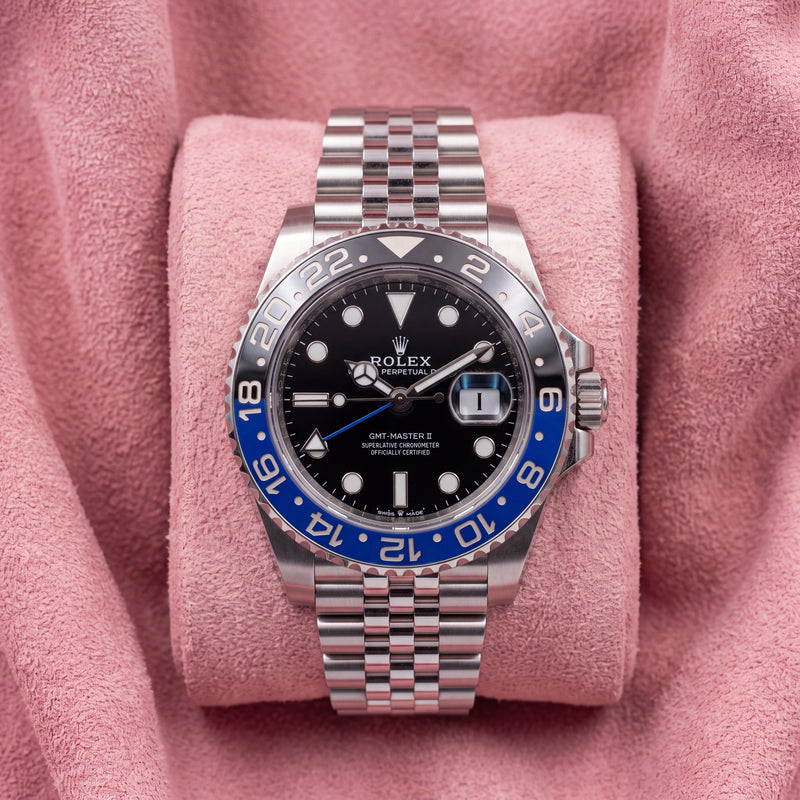 Front view of black-dial GMT-Master II with blue-and-black bezel and Jubilee bracelet on pink cushion