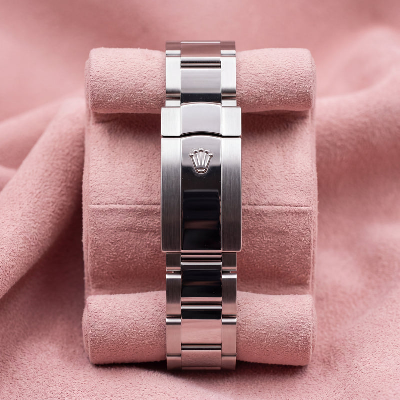 Rolex Oyster bracelet with polished centre links and crown-embossed clasp on a pink cushion