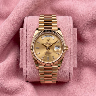 Rolex Day-Date 40 with champagne baguette dial, fluted bezel and President bracelet on a pink cushion