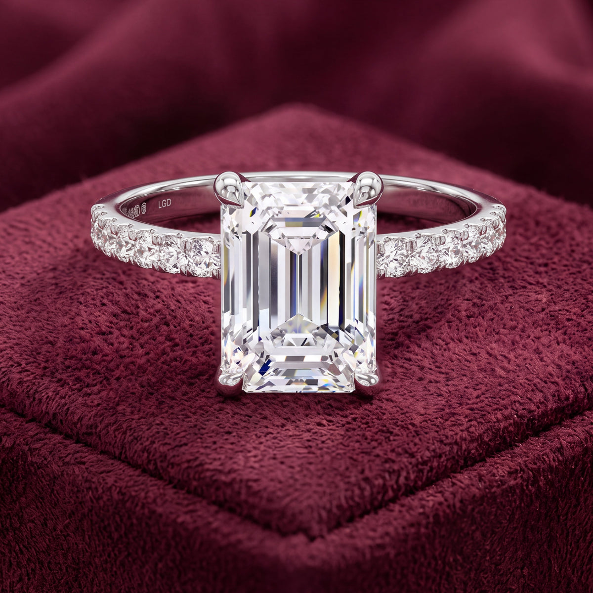 Platinum emerald-cut diamond engagement ring with diamond shoulders, front view