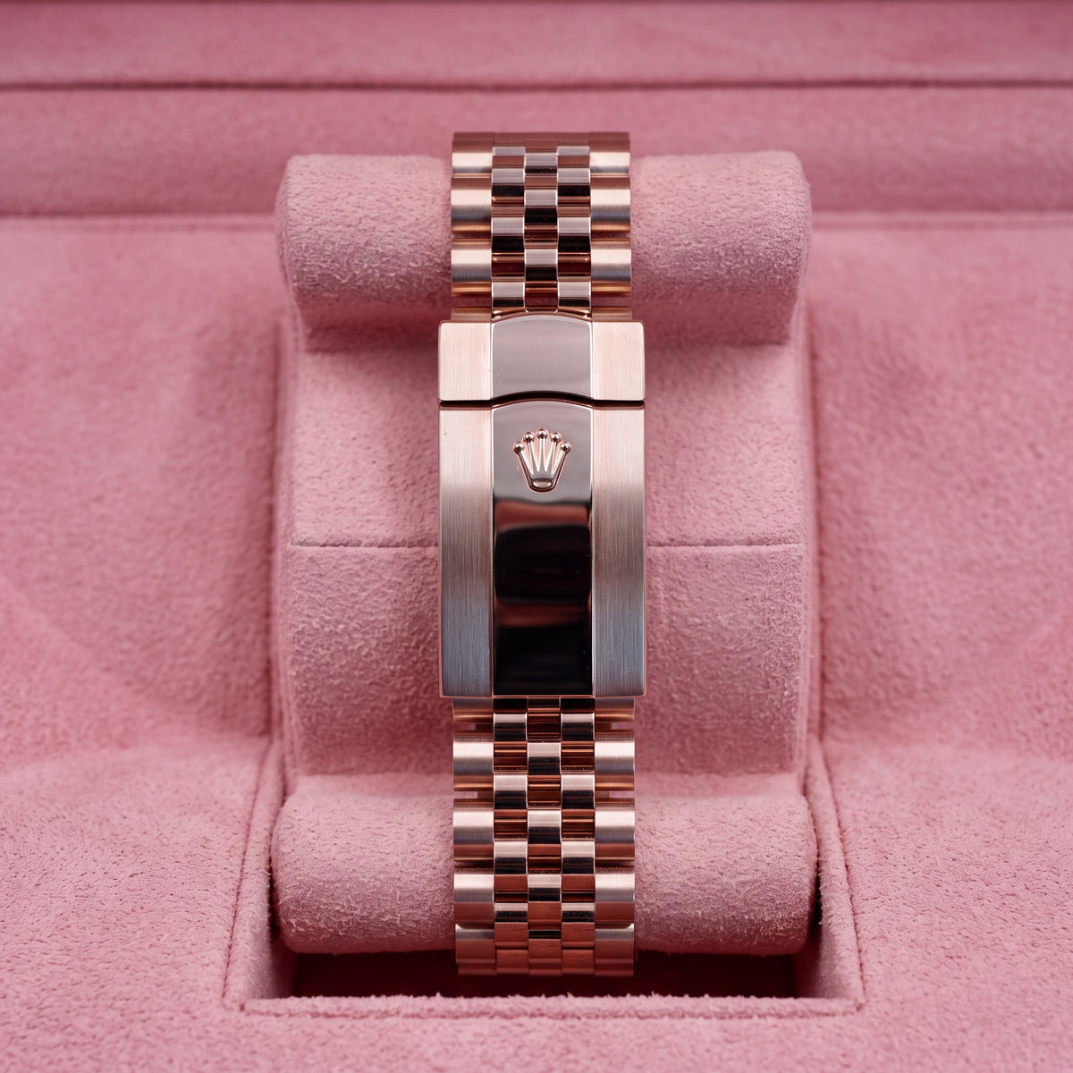 Rear view of rose-tone Jubilee bracelet and crown-emblem clasp on pink cushion