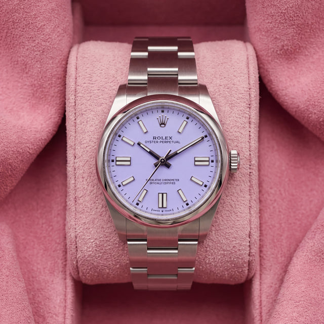 Front view of lavender-dial Oyster Perpetual watch with smooth steel bezel and Oyster bracelet on pink cushion