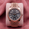 Front view of rose-tone Sky-Dweller with rhodium dial, fluted bezel and Jubilee bracelet on pink cushion