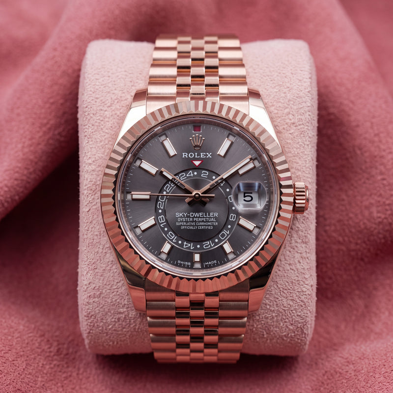 Front view of rose-tone Sky-Dweller with rhodium dial, fluted bezel and Jubilee bracelet on pink cushion