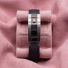 Black Oysterflex-style strap and metal crown-emblem clasp photographed on pink cushion