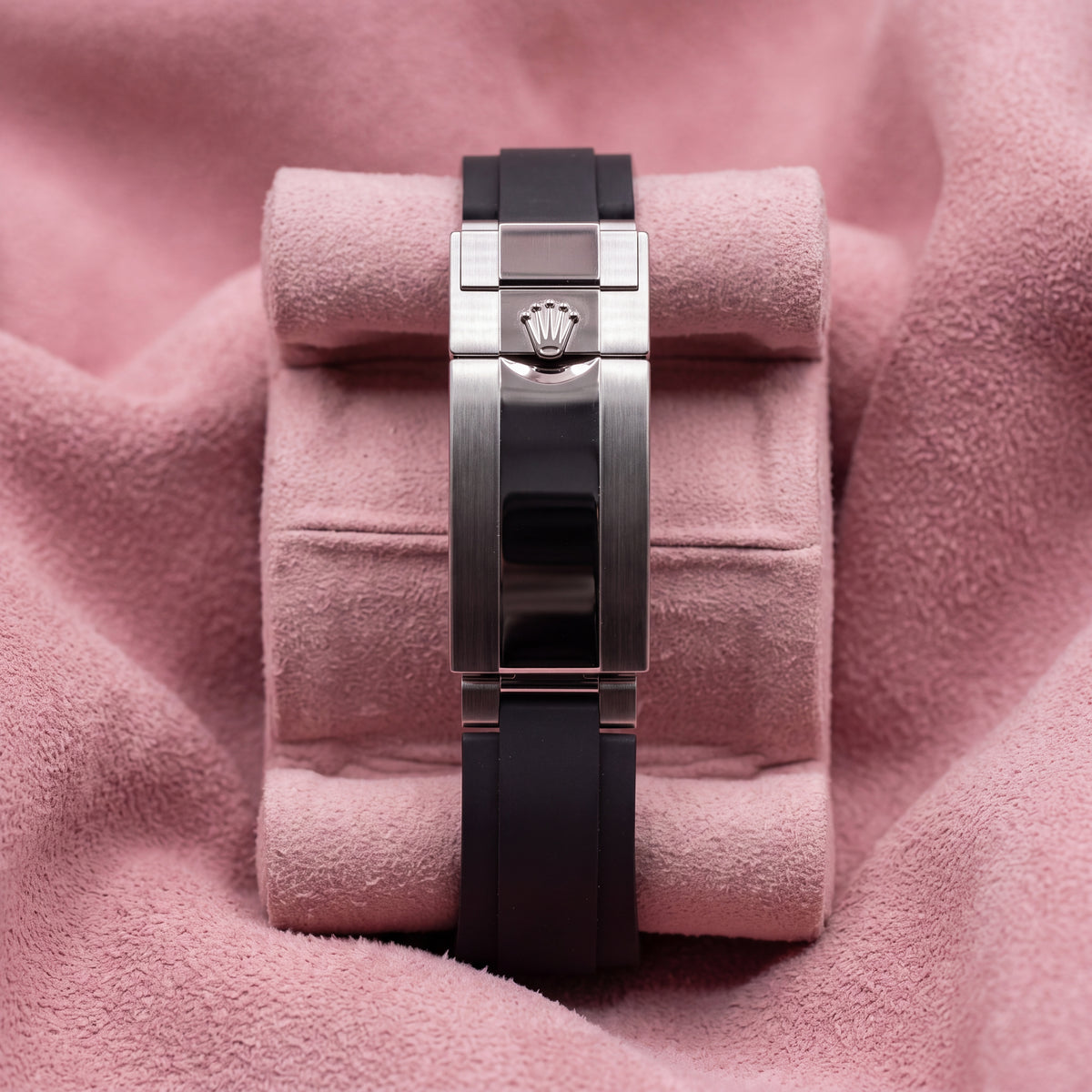 Black Oysterflex-style strap and metal crown-emblem clasp photographed on pink cushion