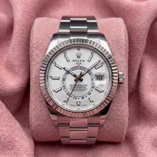 Rolex Sky-Dweller with white dial, fluted bezel and Oyster bracelet on a pink cushion