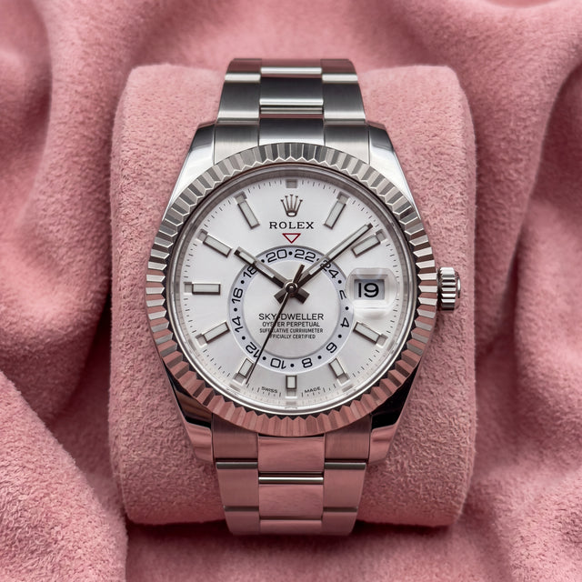 Rolex Sky-Dweller with white dial, fluted bezel and Oyster bracelet on a pink cushion