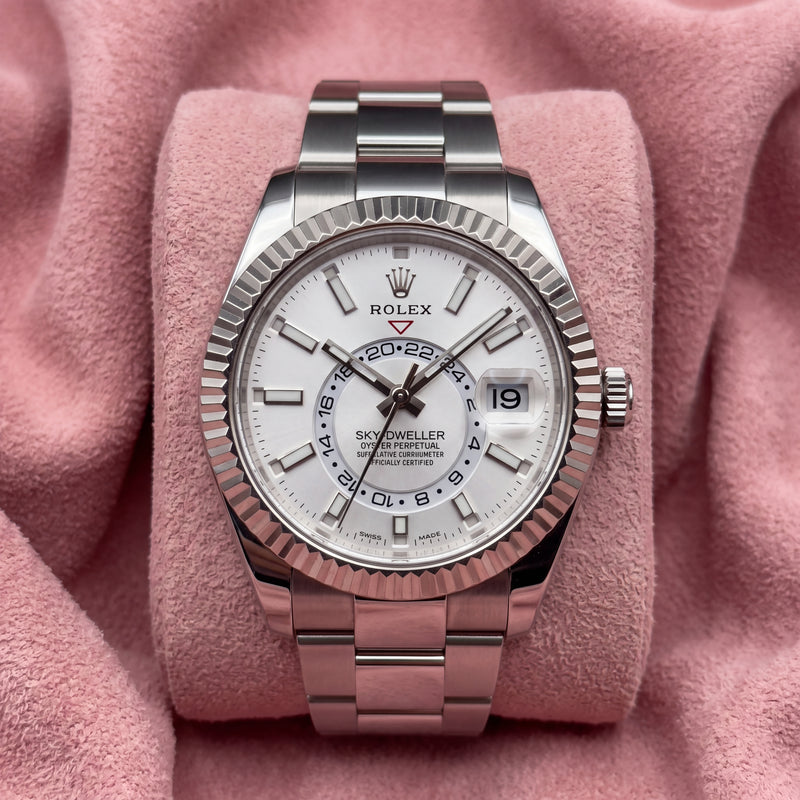 Rolex Sky-Dweller with white dial, fluted bezel and Oyster bracelet on a pink cushion