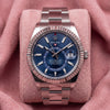 Rolex Sky-Dweller with blue dial, fluted bezel and Oyster bracelet on a pink cushion