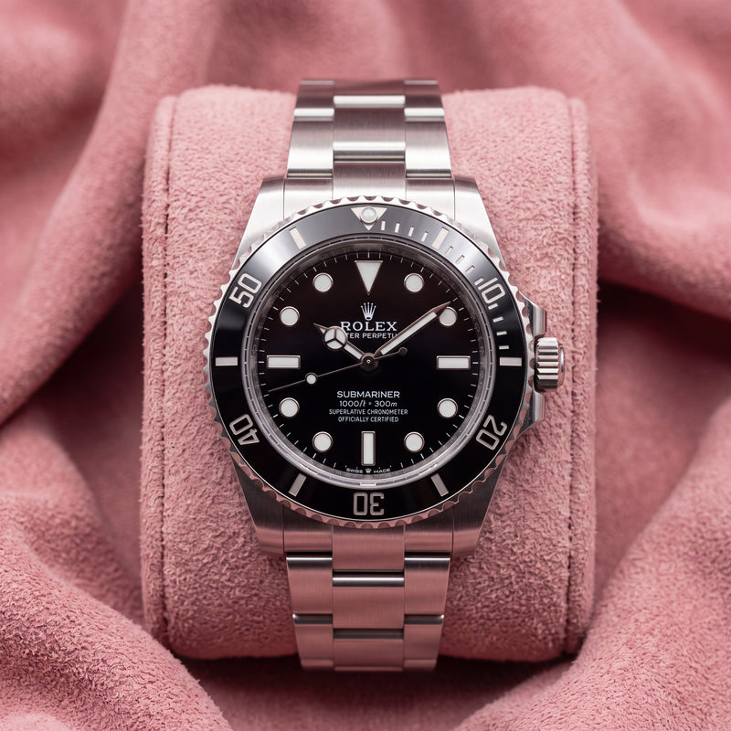 Front view of black-dial Submariner No-Date with black dive bezel and steel bracelet on pink cushion